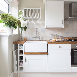 kitchen with white cabinets and wooden worktop and white washbasin
