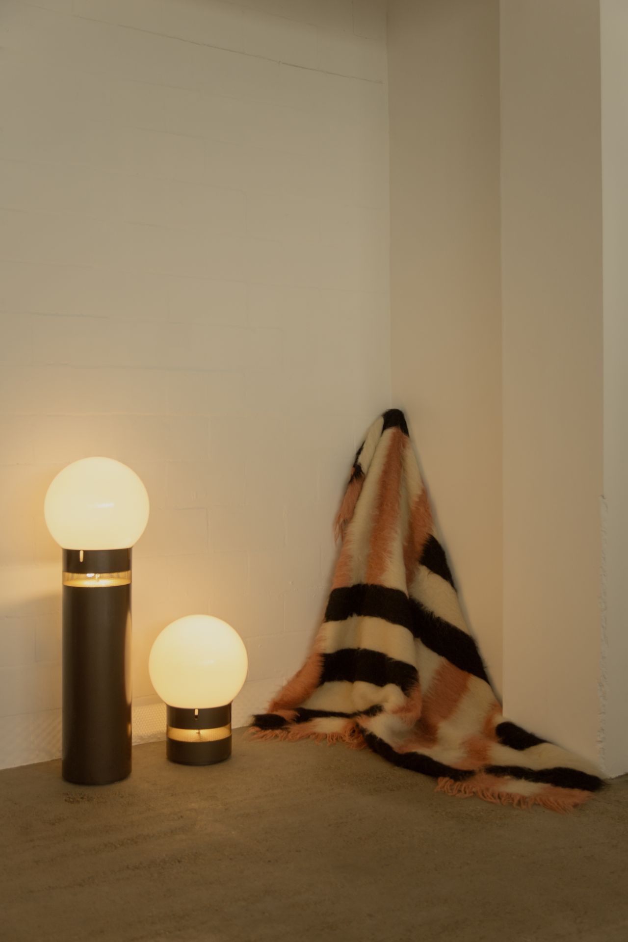 A series of textile creations with an abstract, textural wool feel sit in an industrial showroom alongside iconic modernist designs.