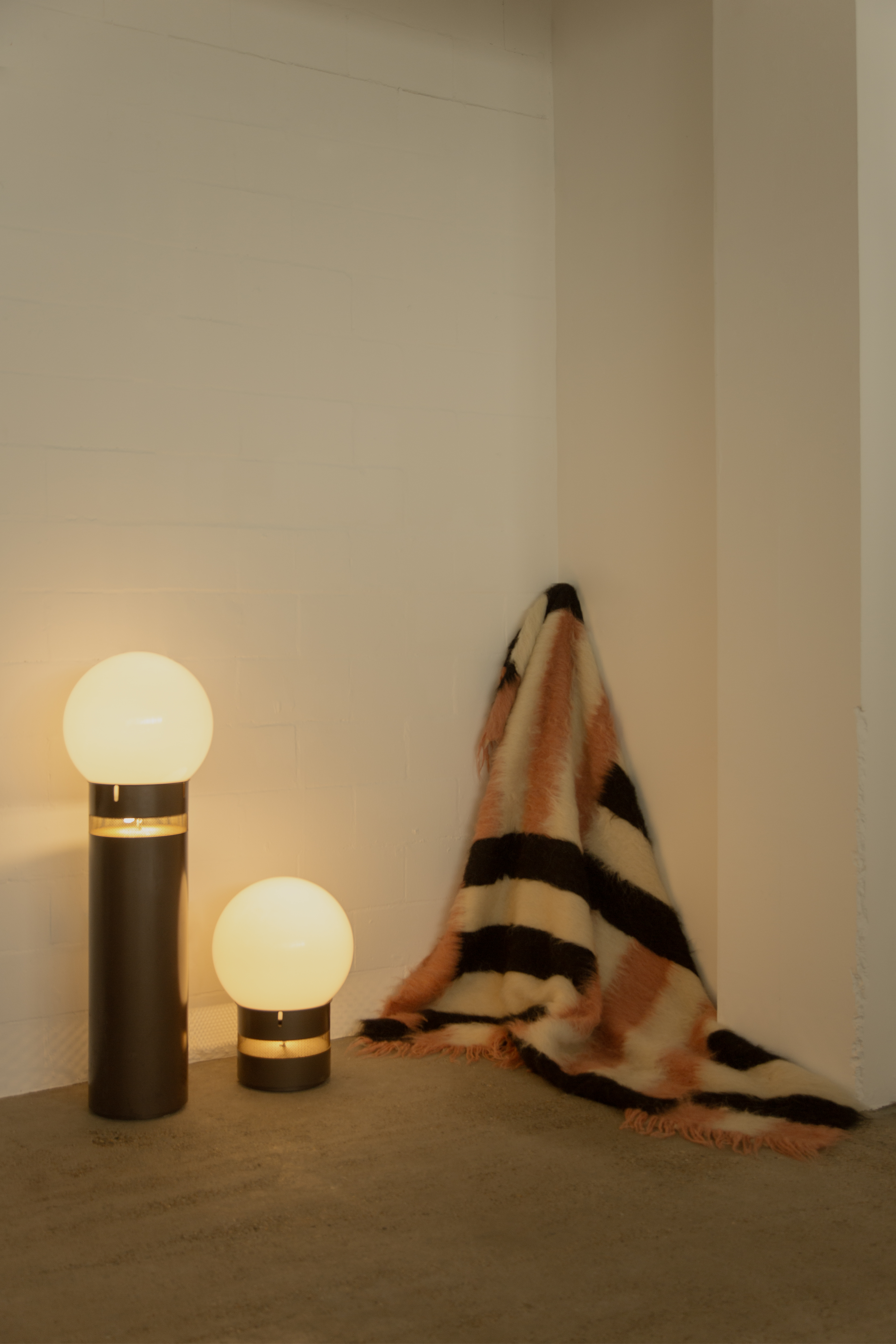 A series of textile creations with an abstract, textural wool feel sit in an industrial showroom alongside iconic modernist designs.