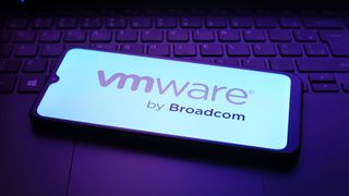 The VMware, Inc. logo appears on a smartphone screen in purple light on a laptop keyboard