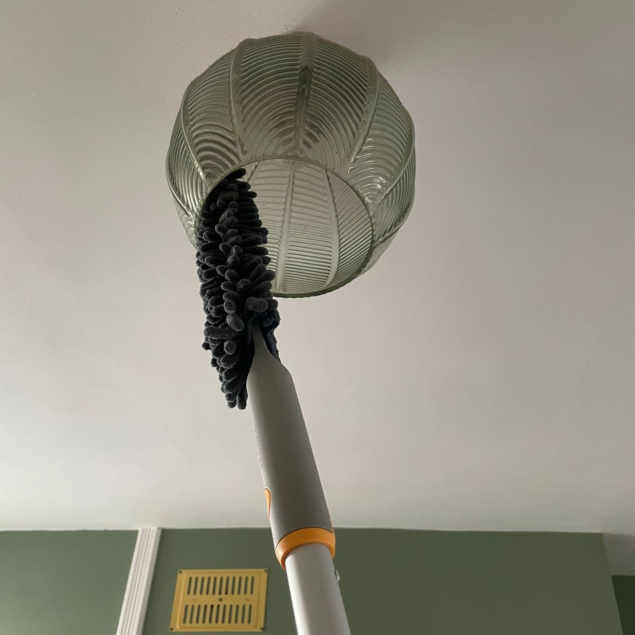 Using the Joseph Joseph duster to dust a green glass lampshade