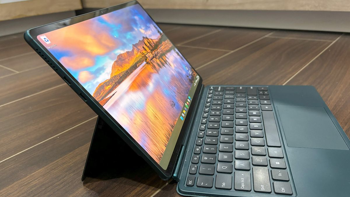 Robo &amp; Kala 2-in-1 laptop at an angle on a wooden floor with the display on