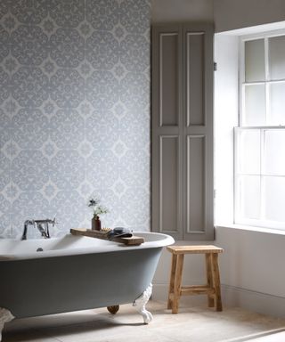Small bathroom tile ideas showing a gray free-standing bath with decorative gray and white wall tiles