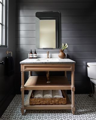 A bathroom in black tone with a freestanding basin