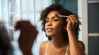 woman brushing eyebrows