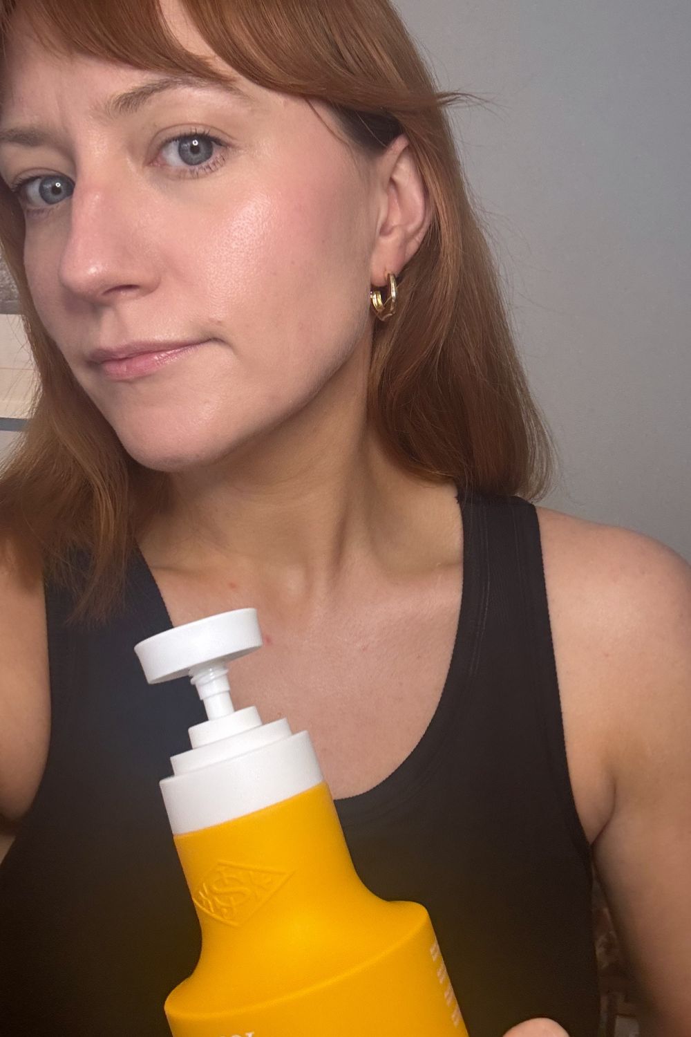 matilda holding a bottle of sol de janeiro badalada lotion