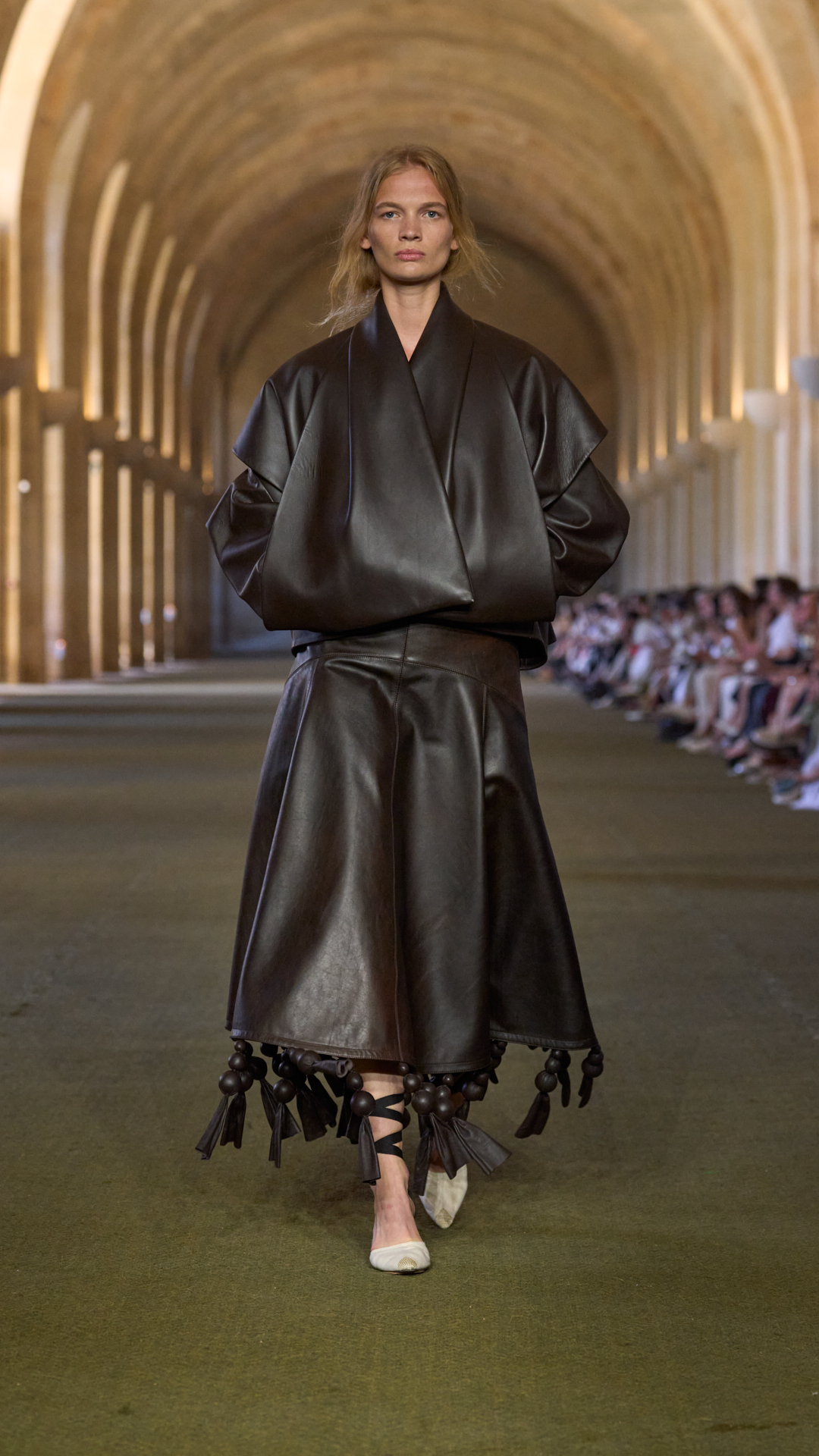 a woman walks down the jacquemus s/s 26 runway.