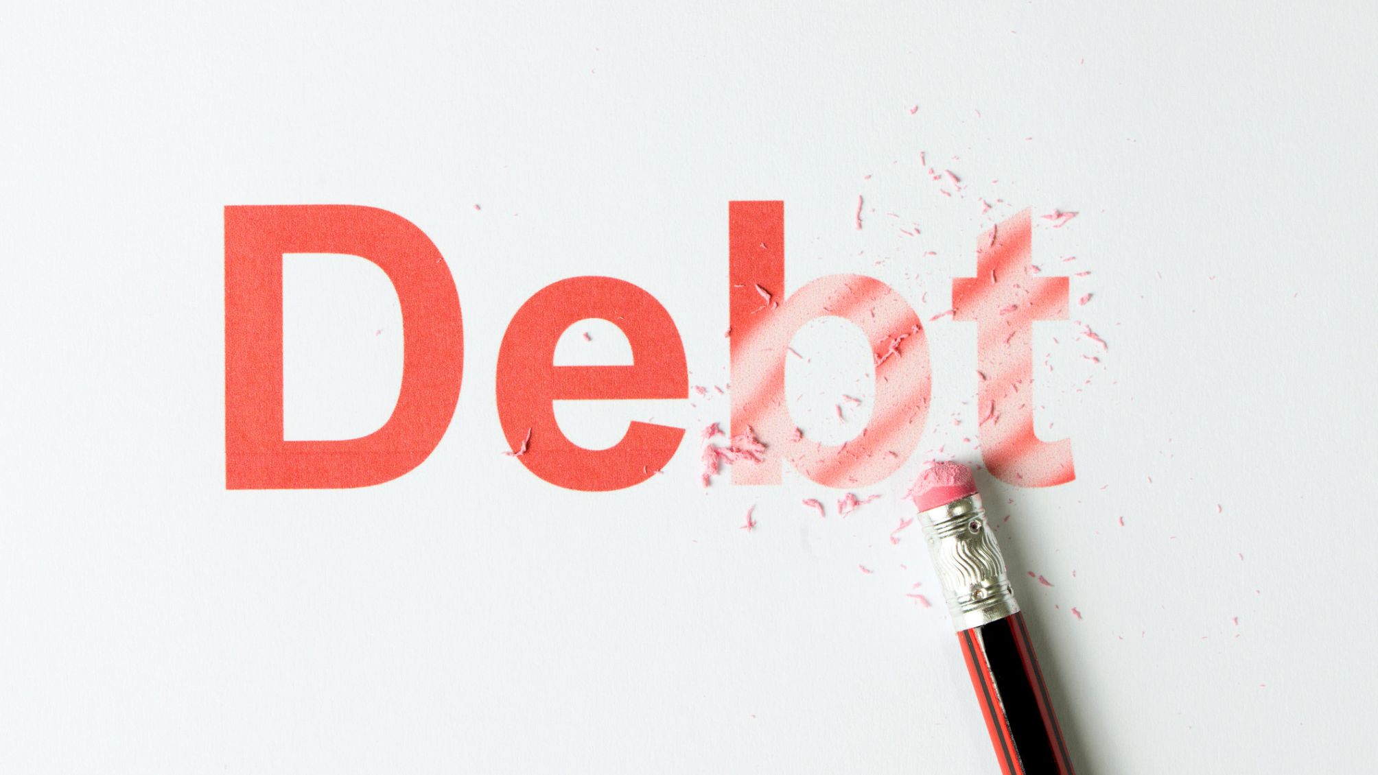 The word debt being erased by a pencil
