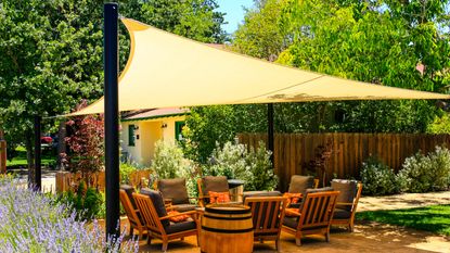 A covered garden deck with chairs and throw pillows in California