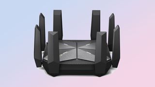 Product shot of the TP-Link Archer AXE300 gaming router, with six upright antennae, on a light purple background.