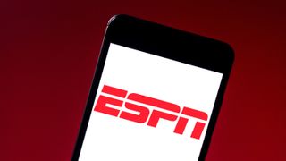 A mobile phone on a red background showing the ESPN logo