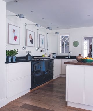 Close up of white kitchen with wooden floor and black Aga