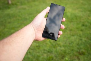 A black Sony Xperia 1 V camera phone being held in a left hand