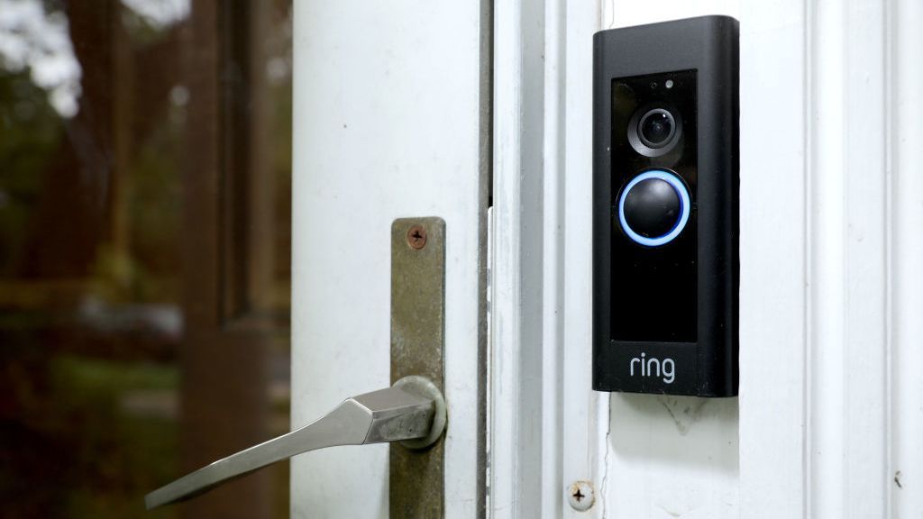 A ring doorbell fixed next to a door on the wall