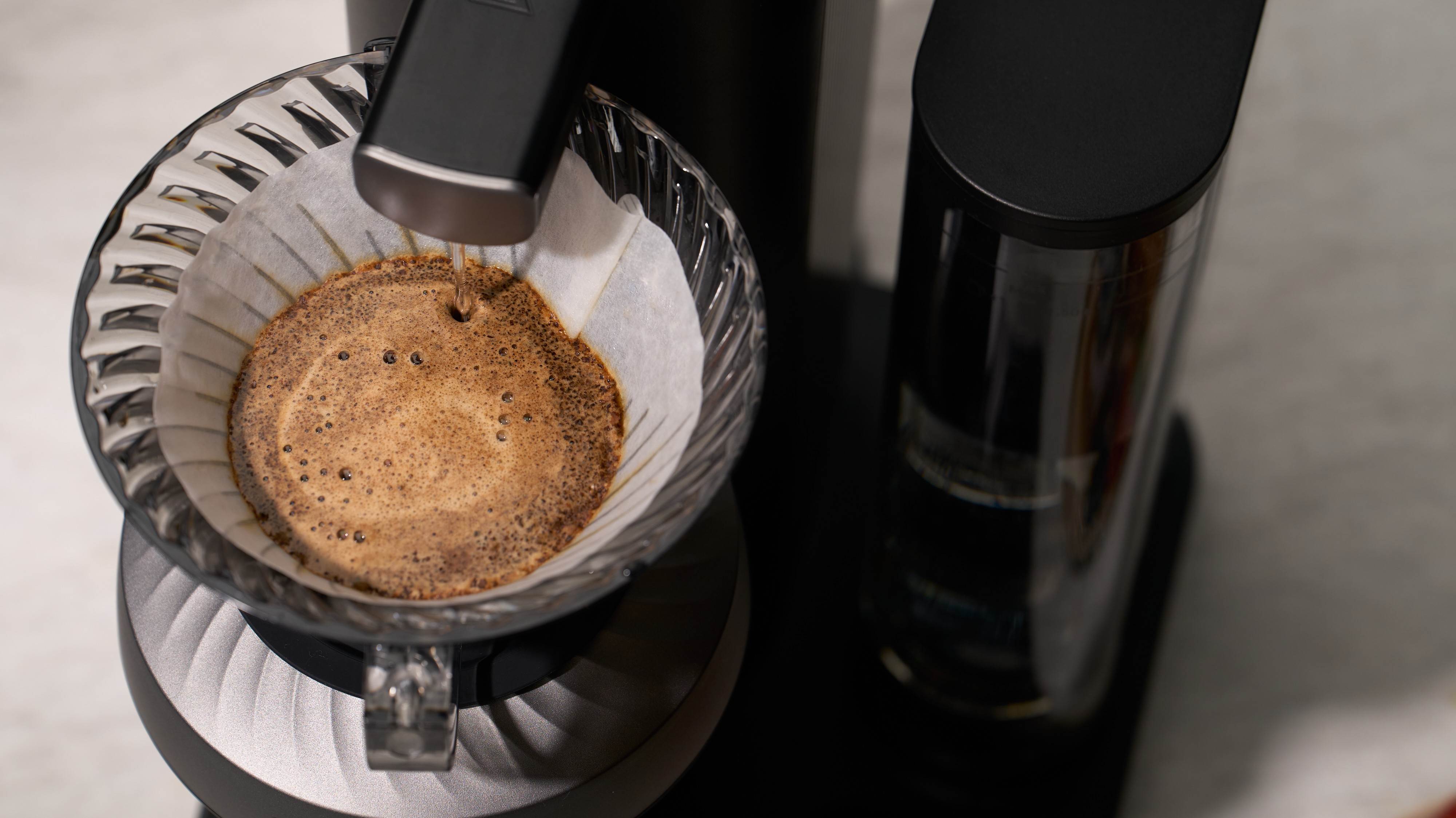 Cosori Juni drip coffee machine pouring water over ground coffee