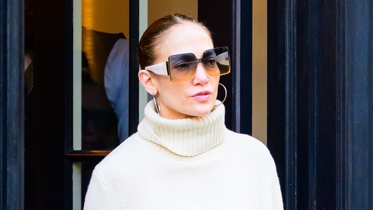 Jennifer Lopez in New York City April 2024 wearing a white turtleneck sweater and hoop earrings