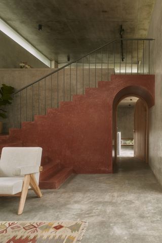 Cabin House by Taliesyn terracotta red arch and katte inspired staircase