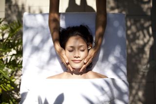 A relaxed woman enjoying a facial massage.
