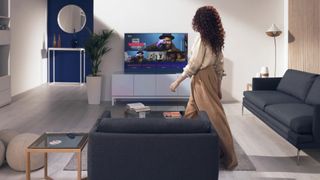 Woman walking to chair in living room with Sky Glass