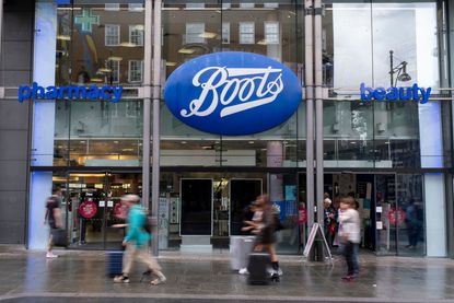 Shoppers and visitors out on Oxford Street pass Boots the chemist