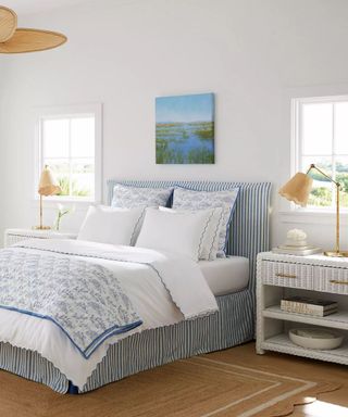 blue and white coastal style bedroom with a striped bed and scalloped bedding