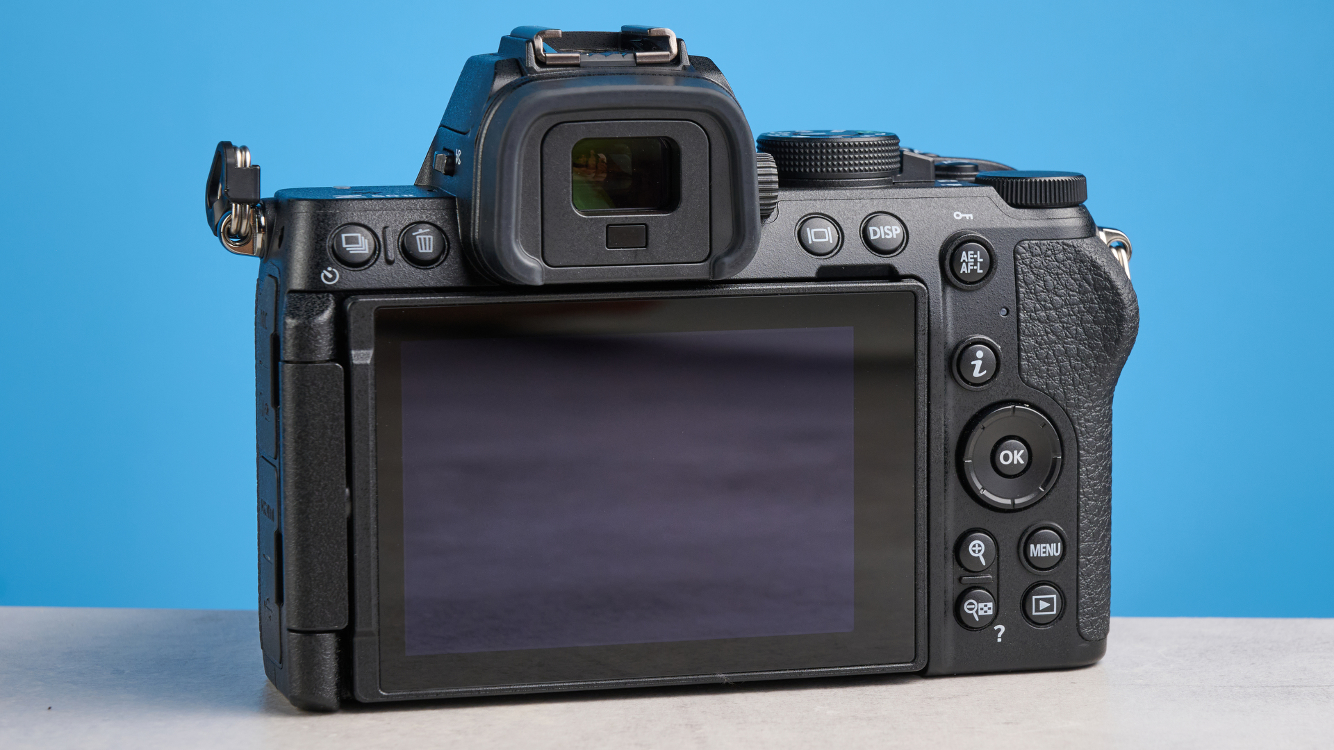 The Nikon Z50II rear body on a stone surface with a blue background