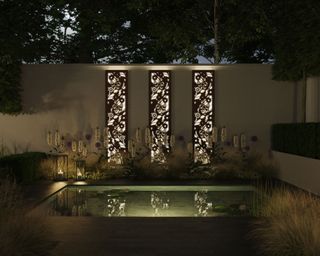 night time garden with pool, screen and lanterns