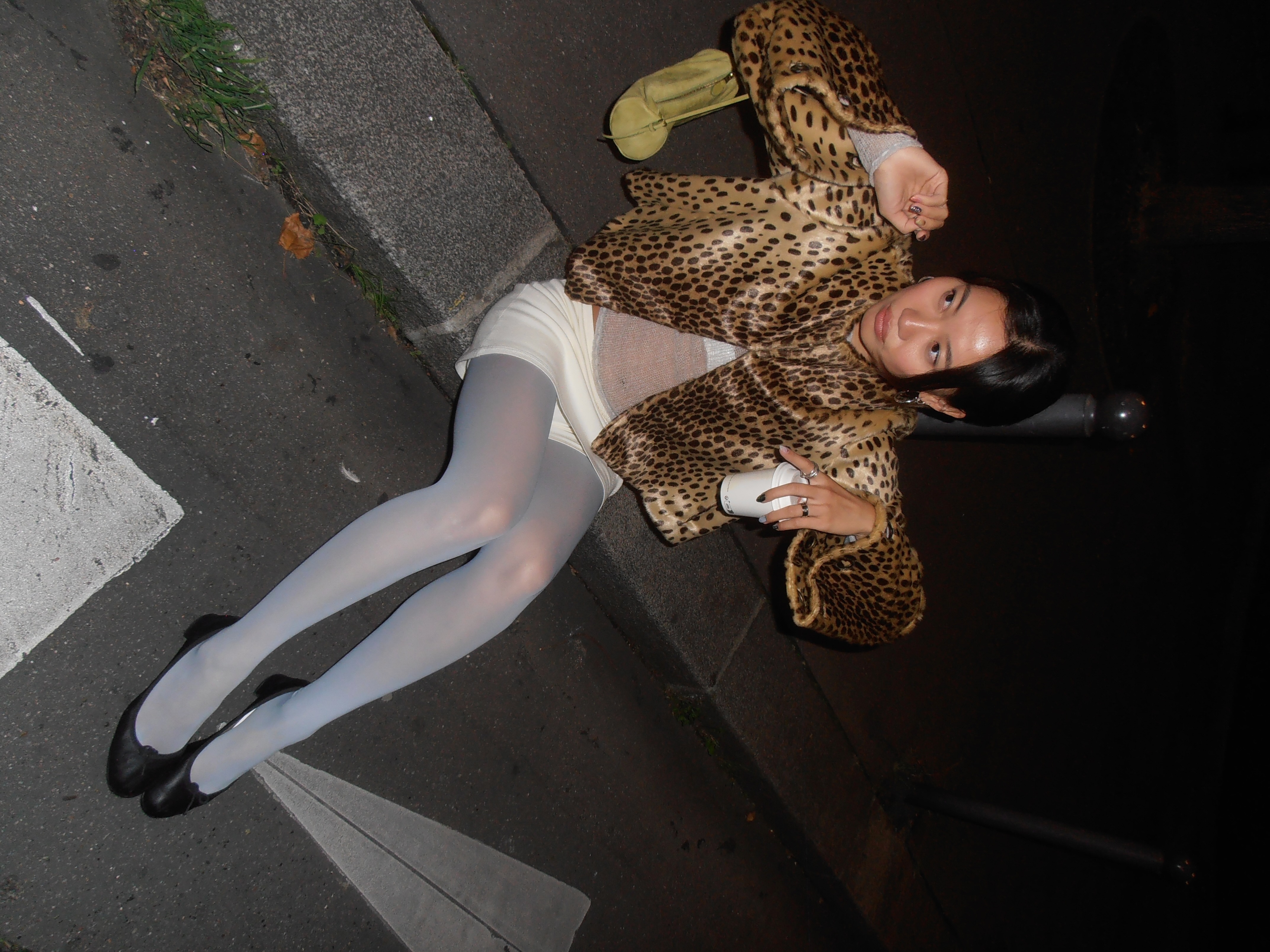 Vivian Li wearing blue colorful tights with a white mini skirt and leopard printed coat at Paris Fashion Week.