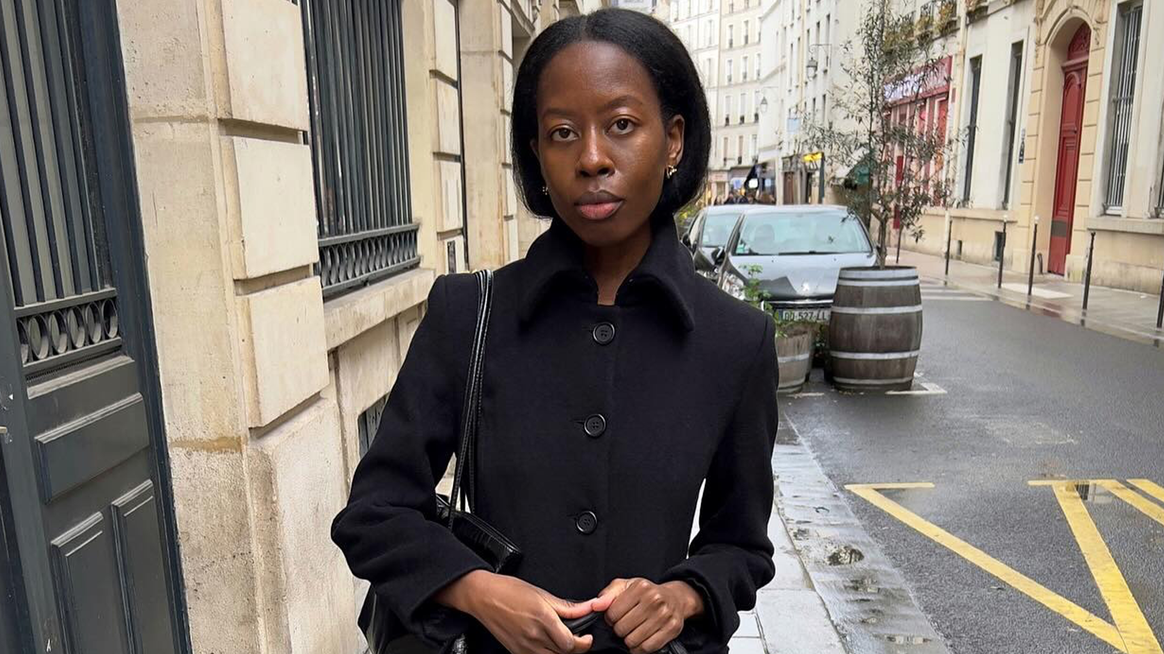 Influencer wearing black car coat and straight leg denim on streets of Paris.