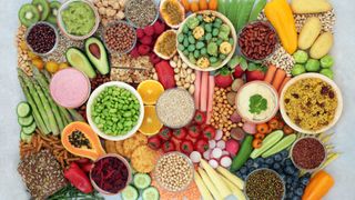A collection of foods to eat on the whole foods, plant based diet including nuts and seeds, quinoa, vegan yogurt and hummus, vegetables and fruit