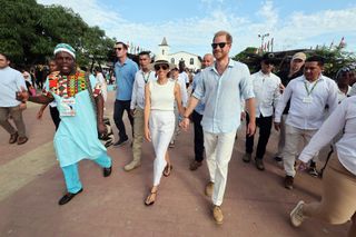 Meghan Markle and Prince Harry walking in Colombia together while Meghan wears an all white outfit