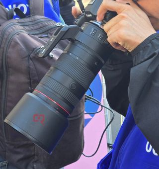 Canon lens being held in two hands and being used to take an image