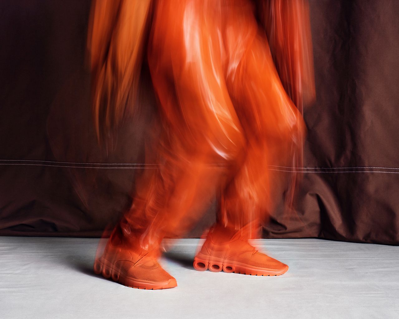 A red Ferragamo sneaker worn with all-red outfit