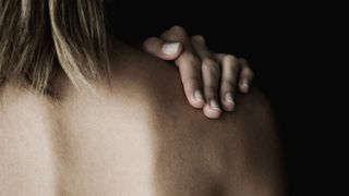 how to get rid of back acne tight image of woman touching her shoulder