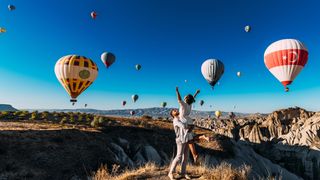 Couple on honeymoon with balloons in background.