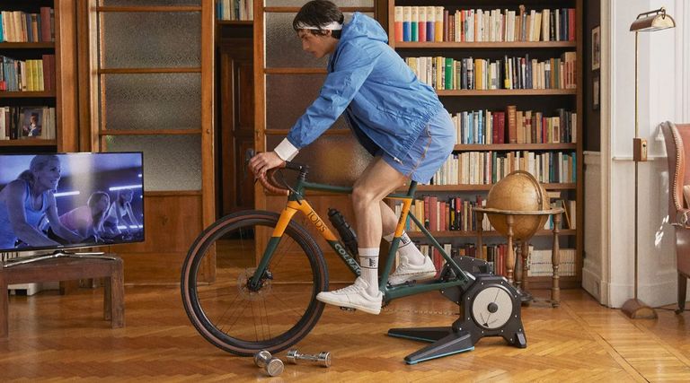Colnago x Tod's T bike with a rider on a turbo trainer with a bookcase in the background