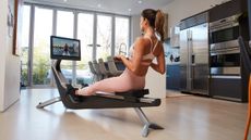 Woman rowing on Hydrow rowing machine in domestic setting