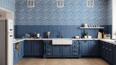 A blue kitchen with painted cabinets, a large farmhouse sink, and blue floral wallpaper on the walls