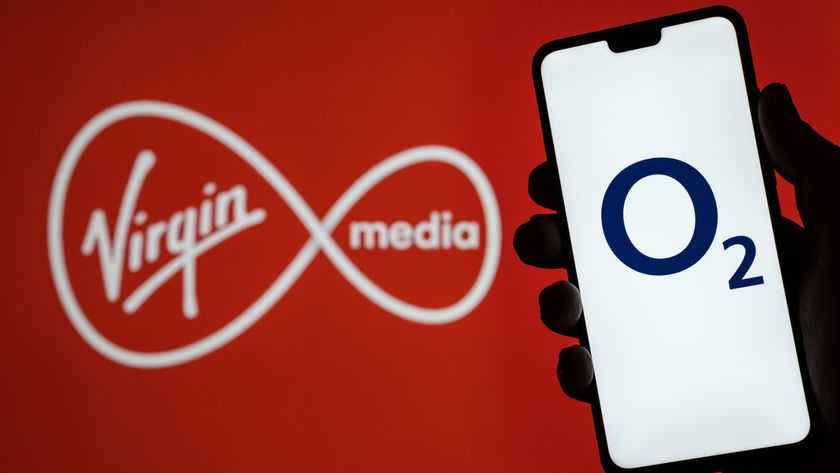 Person holding phone showing O2 logo in front of Virgin Media logo