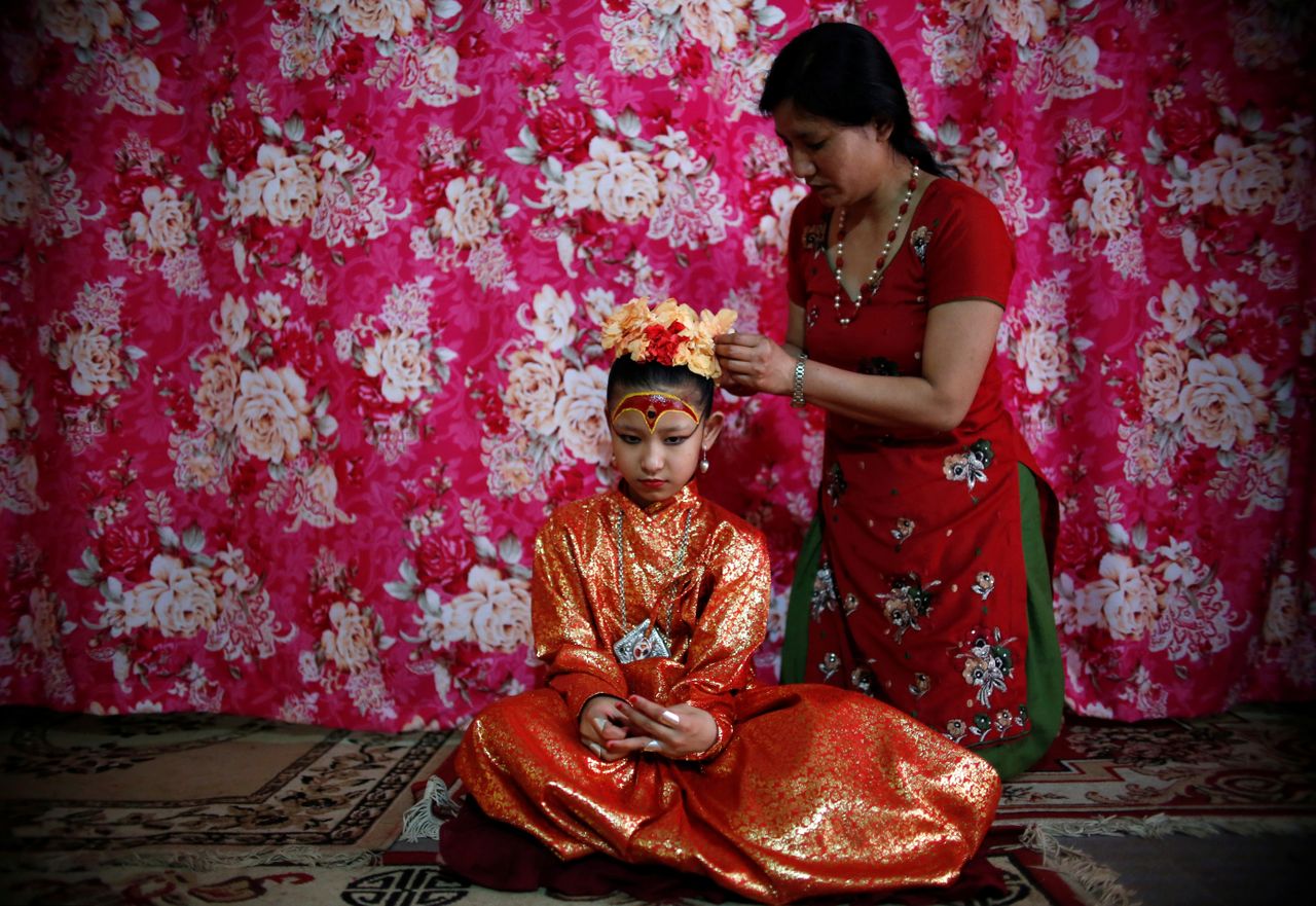 Living Goddess Kumari Unikia Bajracharya is adorned by her mother.