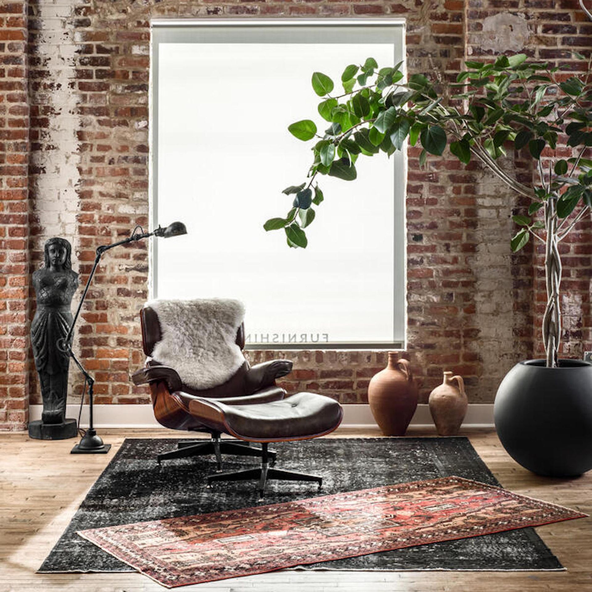 Ruang tamu yang terinspirasi oleh alam dengan tempat duduk kulit dan tanaman hias yang besar