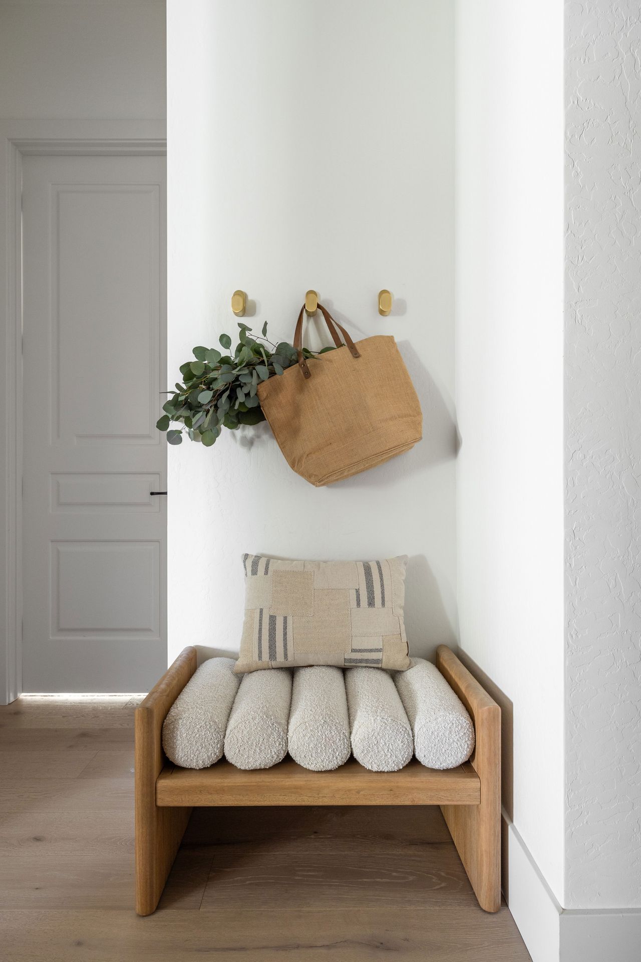 a small wooden seat with round boucle cushions