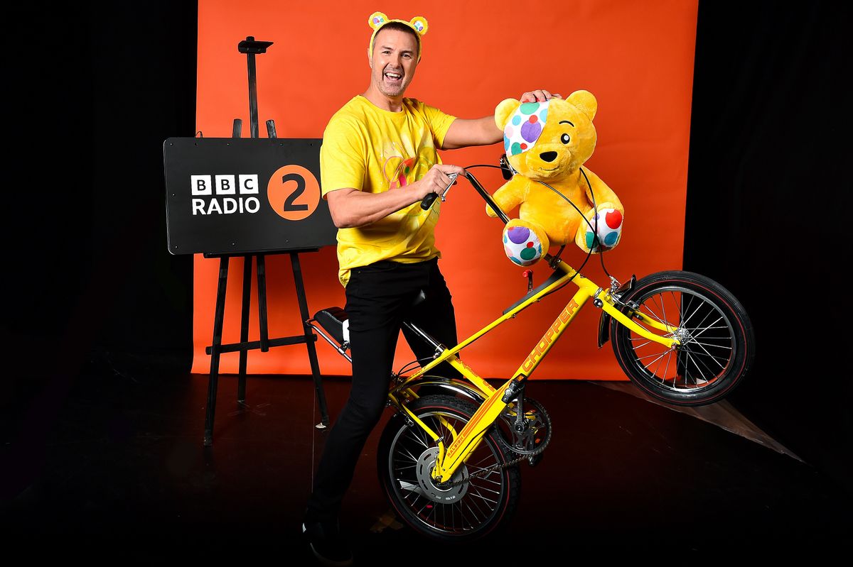 Paddy McGuinness poses with a yellow Chopper, Pudsey Bear and wearing Pudsey Bear ears for Paddy: The Ride of My Life