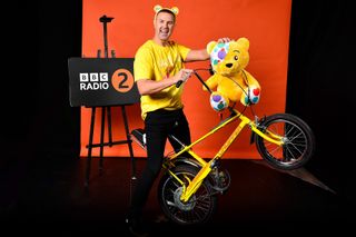 Paddy McGuinness poses with a yellow Chopper, Pudsey Bear and wearing Pudsey Bear ears for Paddy: The Ride of My Life