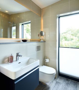 a bathroom with a bottom up blind on the window