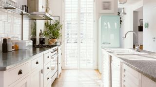 A blue refrigerator in a brightly lit kitchen