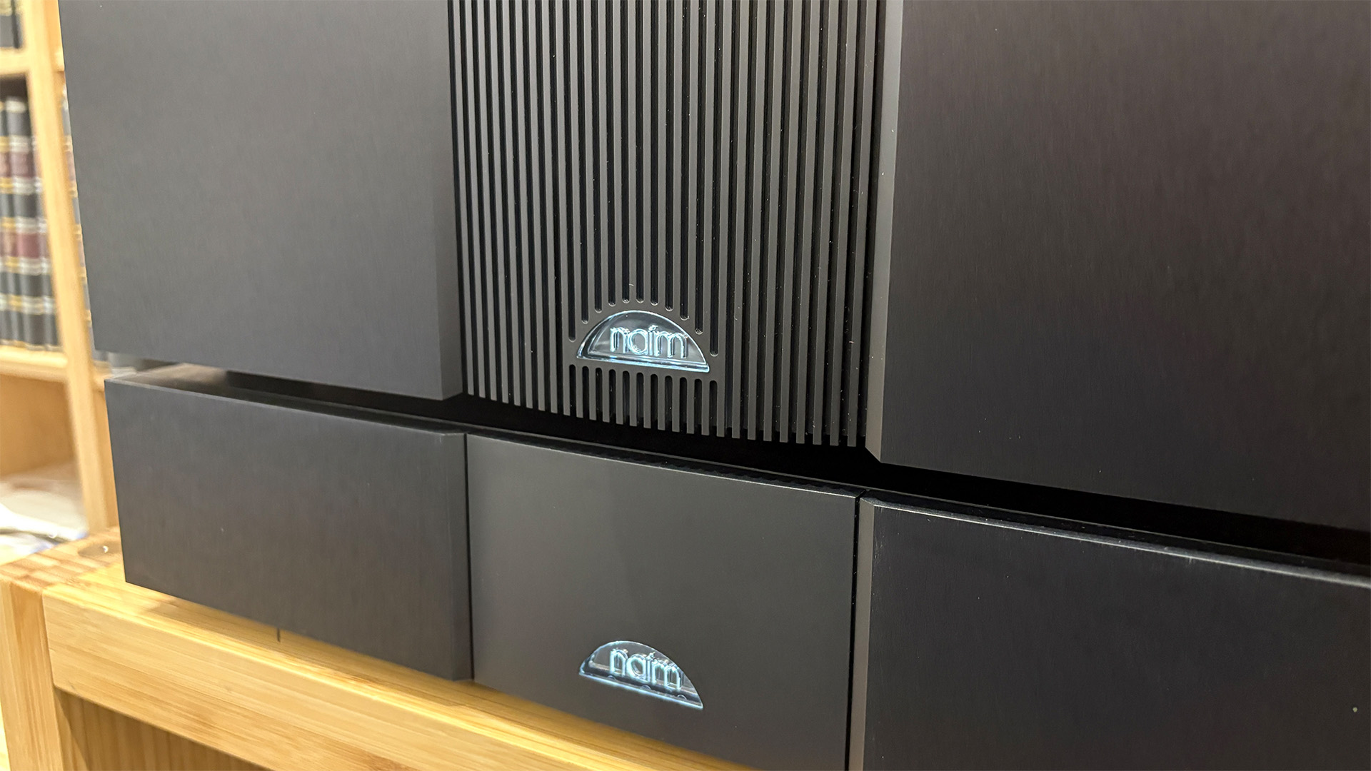 NAP 500 DR power amplifier on wooden hi-fi rack, detail of Naim logos