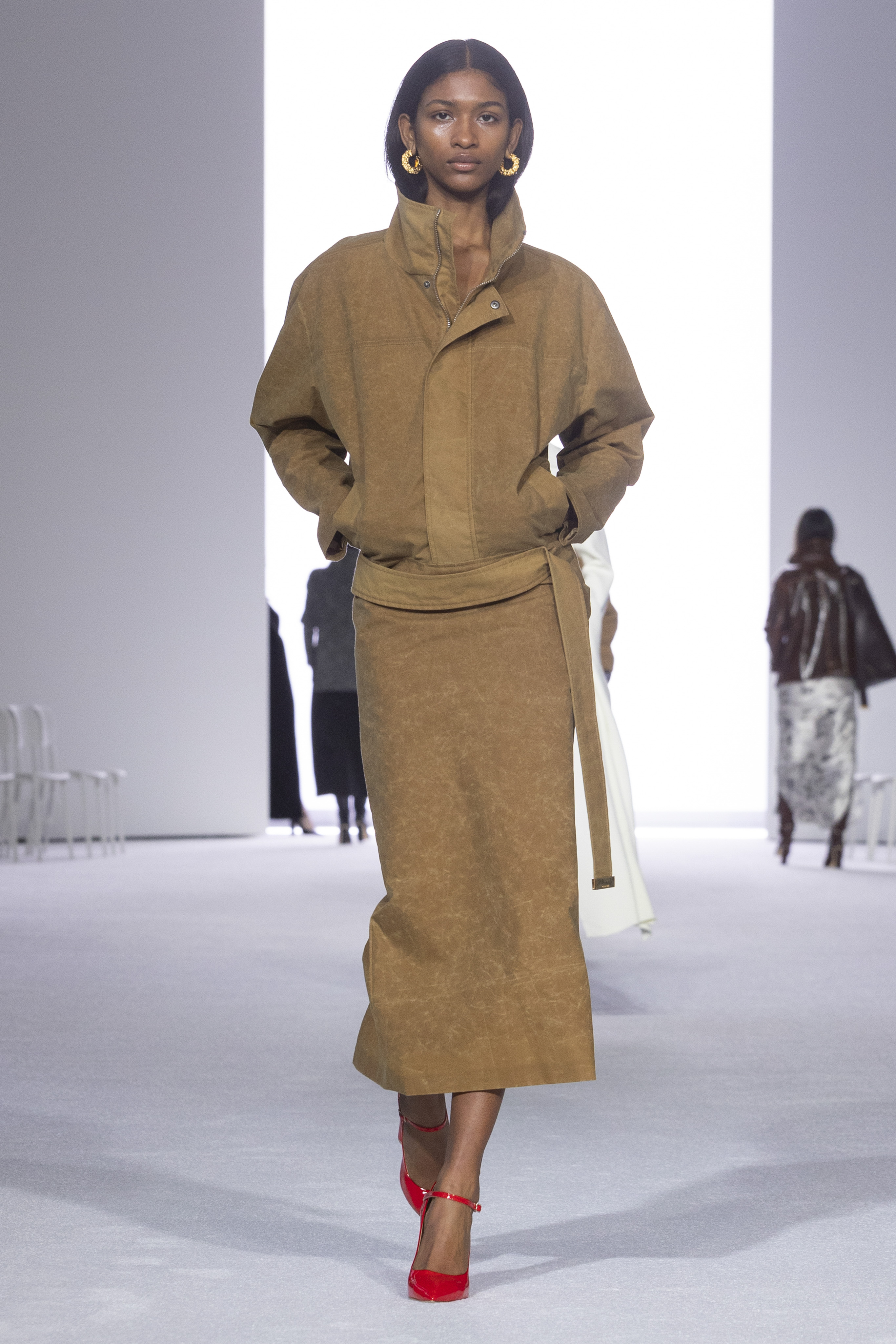 A Brandon Maxwell model wearing a tan workwear jacket with a matching pencil skirt at the FW24 show.