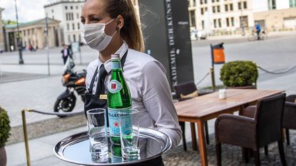 Waitress with a facemask © Maja Hitij/Getty Images