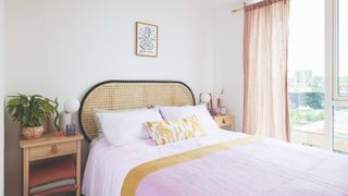 Bed with a cane headboard and pink bedding